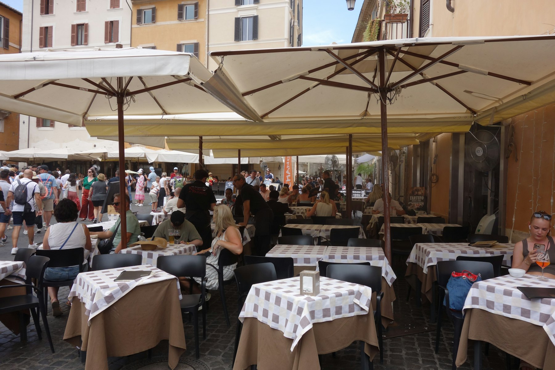 Café-Tische im Gastgarten mit Sonnenschirmen